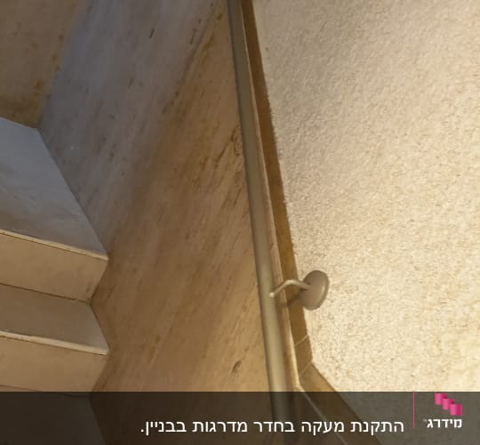 מעקה מתכת על קיר מדרגות אבן